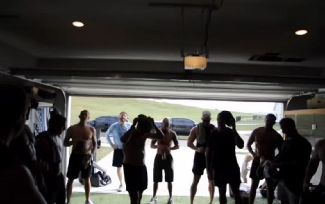 The group inside the garage gym, silhouetted against the open door