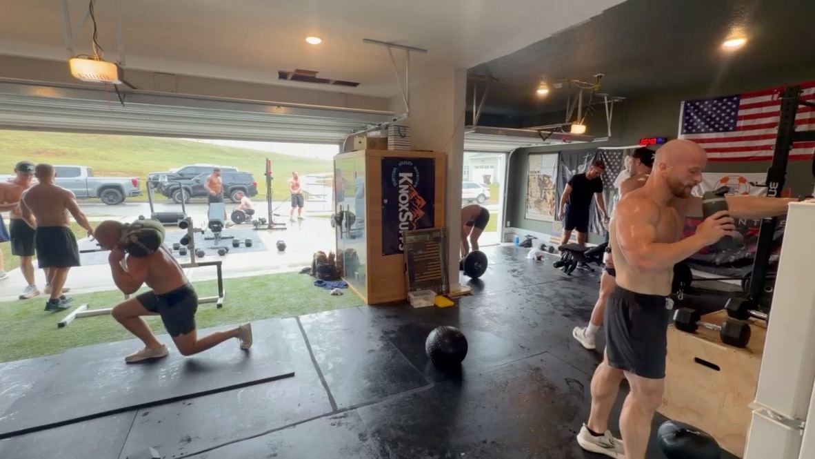 Sandbag lunges inside the garage while others train in the driveway