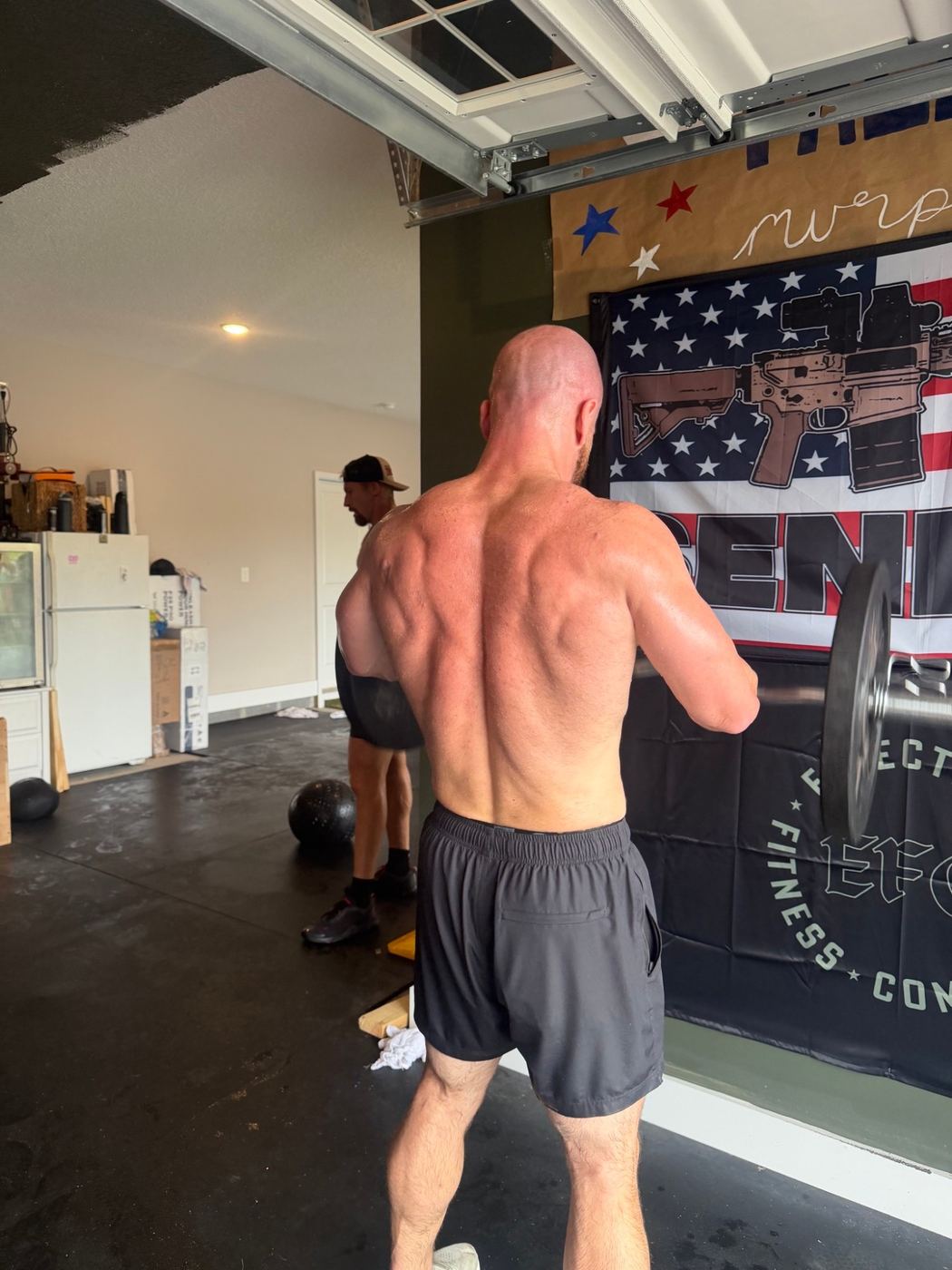 Barbell curls in front of the flag banner